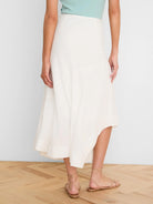 Off-white linen midi skirt with a flowy A-line shape and an asymmetrical hem.