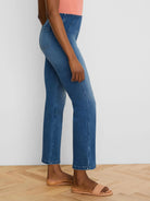 Medium blue ankle bootcut jeans, high-waisted with a structured waistband and diagonal seams.