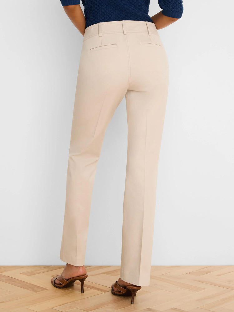 Back view of light beige demi-boot pants with belt loops and subtle slit back pockets. Worn with a navy top.