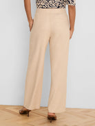Light beige wide-leg linen pants, back view. Features an elastic waist and two rear welt pockets.