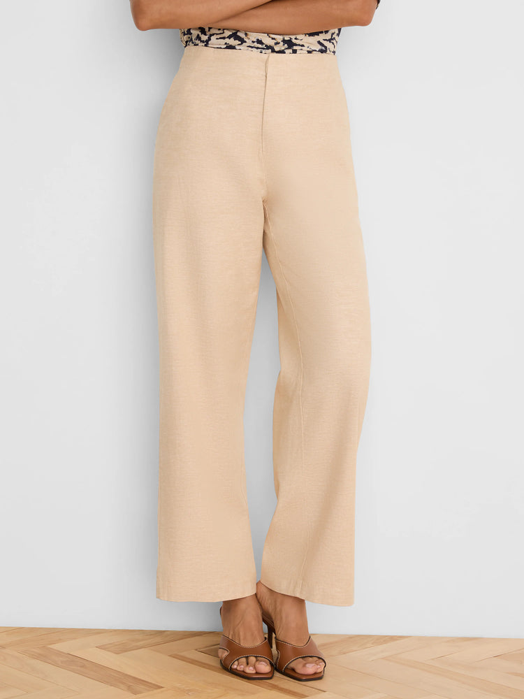 Light beige wide-leg pants, high-waisted, with visible linen texture, falling to the ankles.