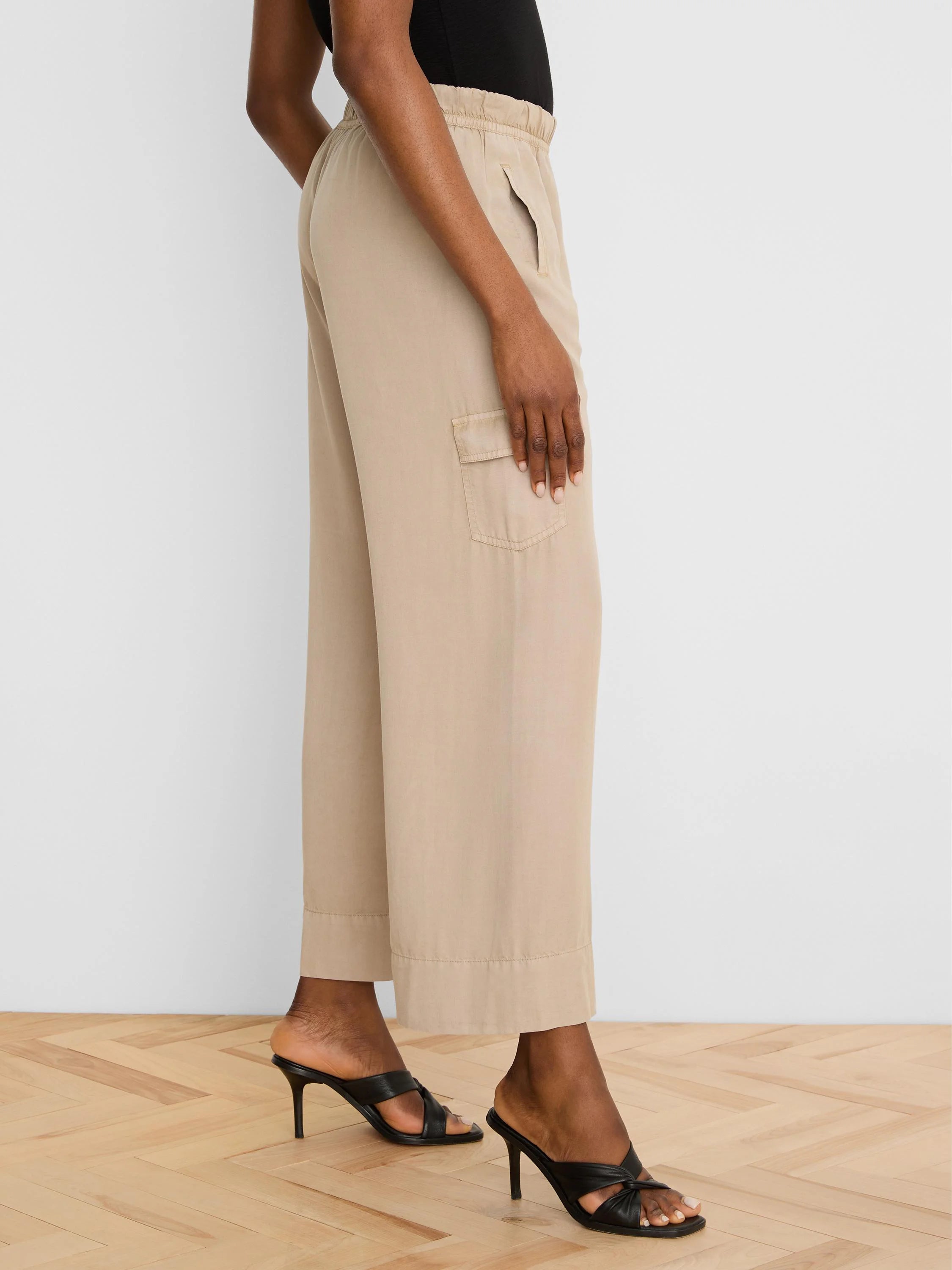 Beige wide-leg drapey cargo ankle pants with an elastic waist and side flap pocket.
