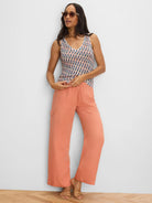 Peach wide-leg drapey cargo ankle pants with a flap pocket on the thigh.