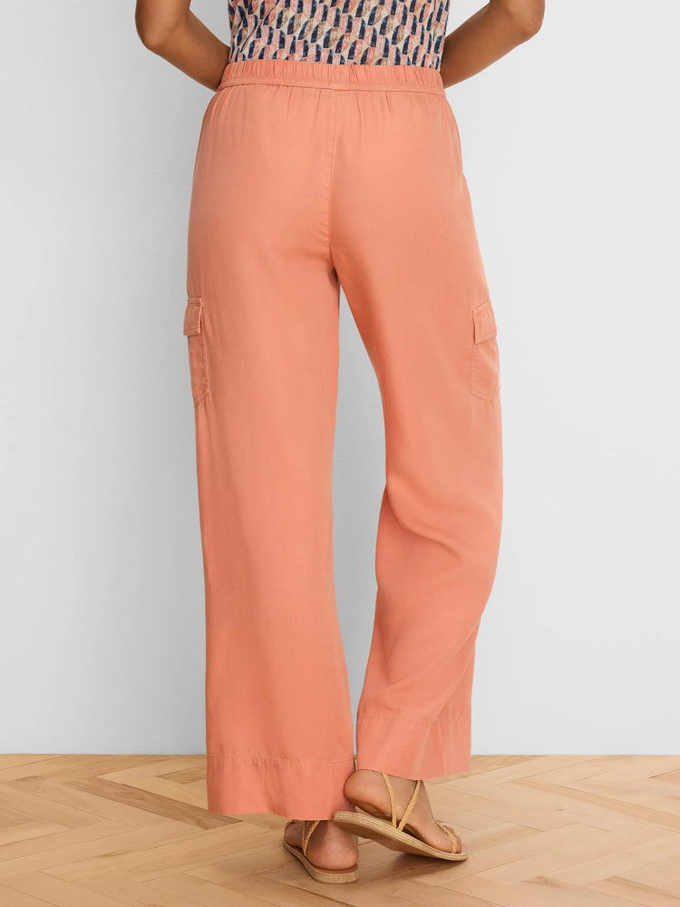 Peach wide leg drapey cargo ankle pants with side pockets and elastic waist, viewed from the back.