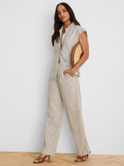 Tan wide-leg linen pants with vertical white stripes.