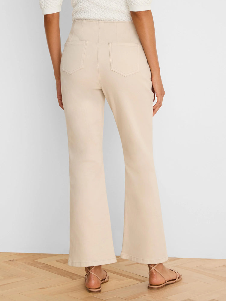 Light beige high-waisted bootcut jeans, viewed from behind, with back patch pockets and visible stitching.