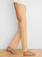 Light tan boot-cut jeans, high-waisted with a subtle flare, shown on a model from the side.