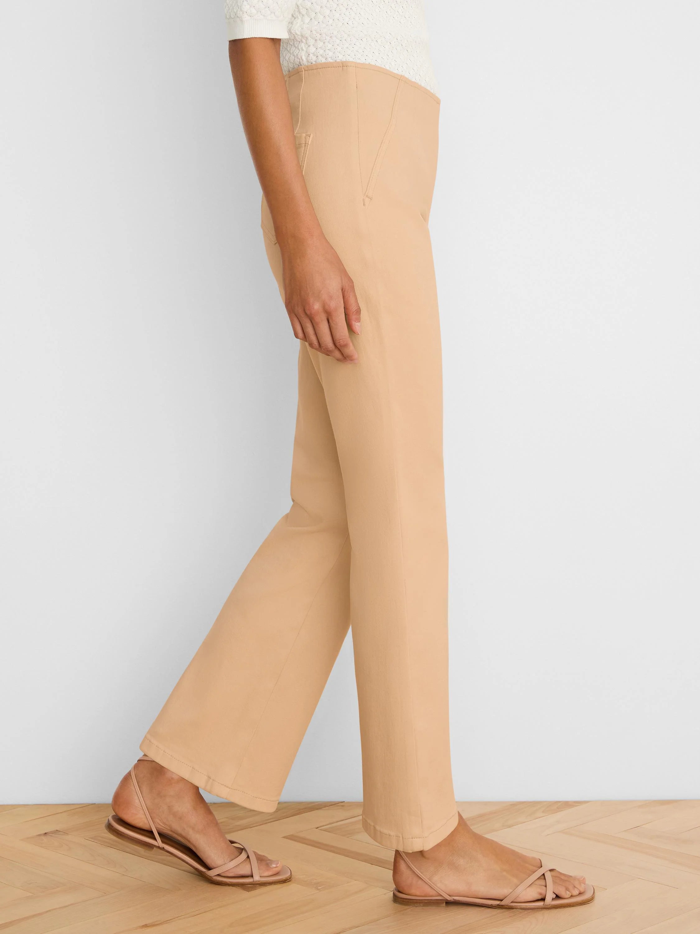 Light tan boot-cut jeans, high-waisted with a subtle flare, shown on a model from the side.