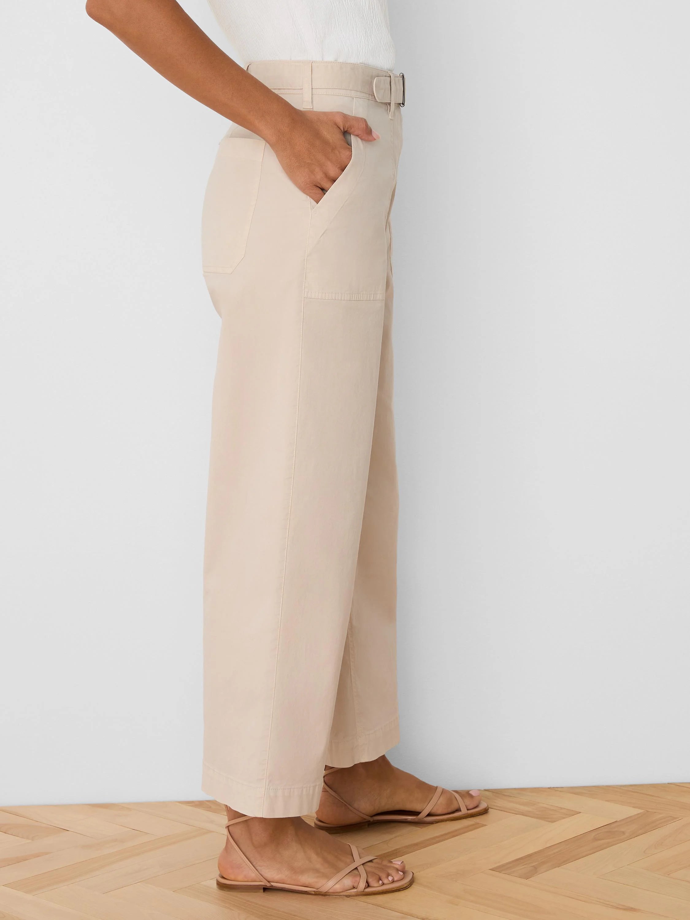 Light beige wide-leg ankle pants with a D-ring belt and side pockets. Fabric appears soft.