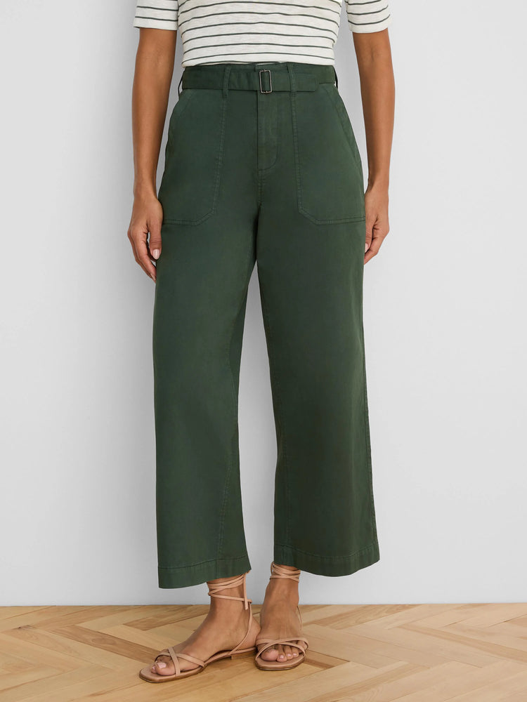 Dark green wide-leg ankle pants feature a belted high waist with a square buckle and prominent front patch pockets.