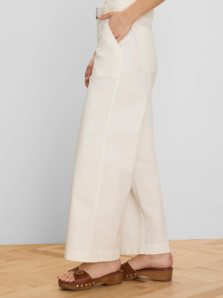 Cream wide-leg ankle pants with a matching belt and front slash pockets. Model's hand in pocket.