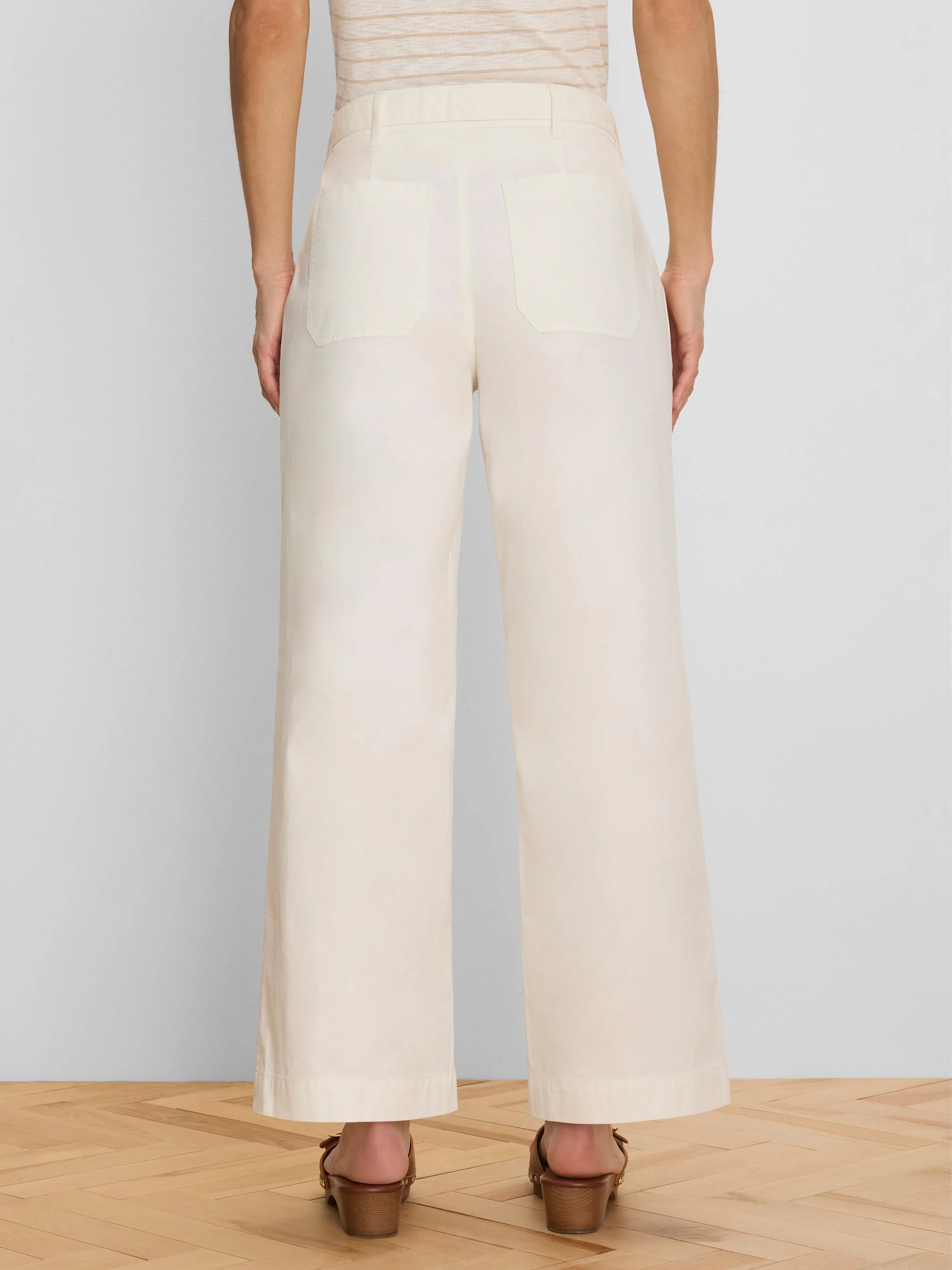 Cream wide-leg ankle pants, back view. Features belt loops and two back patch pockets.