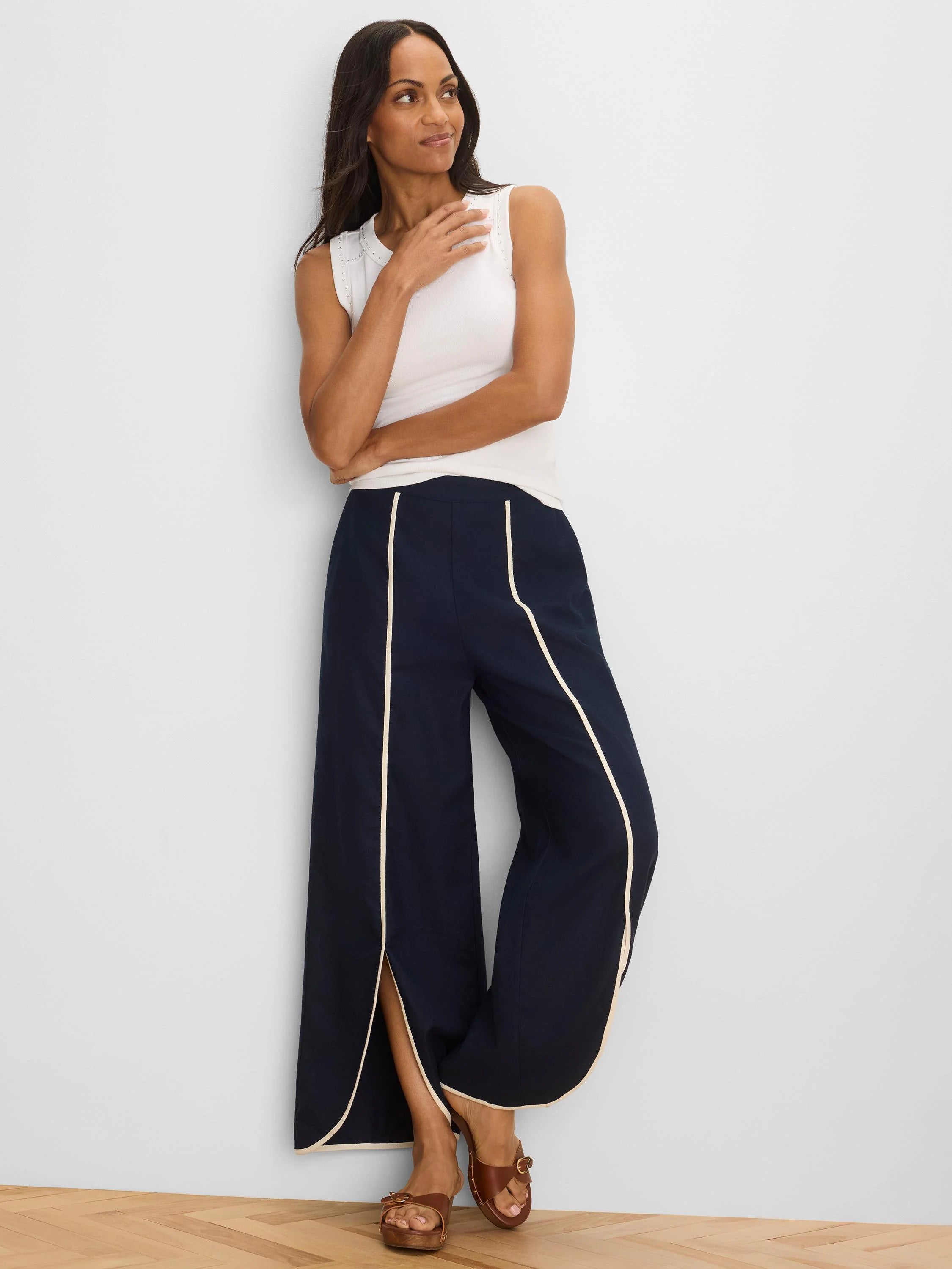 Navy wide-leg pants with cream piping outlining the split side seams.