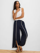 Navy wide-leg pants with cream piping outlining the split side seams.