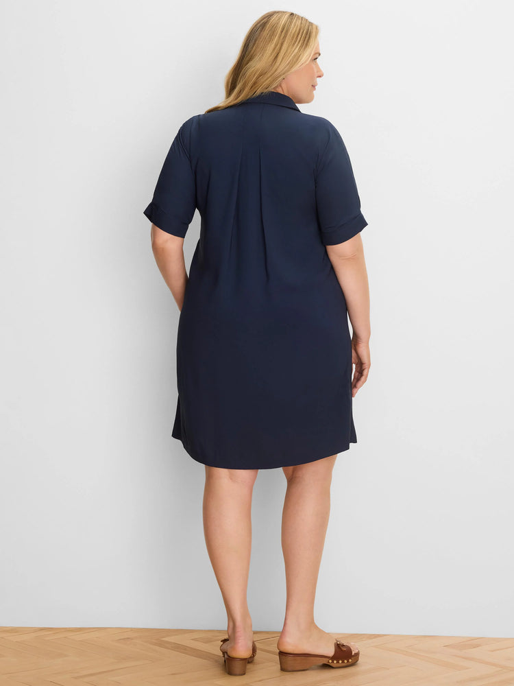 Back view of a dark blue button-down dress. It features a collar, cuffed short sleeves, and back pleats, falling to the knee.