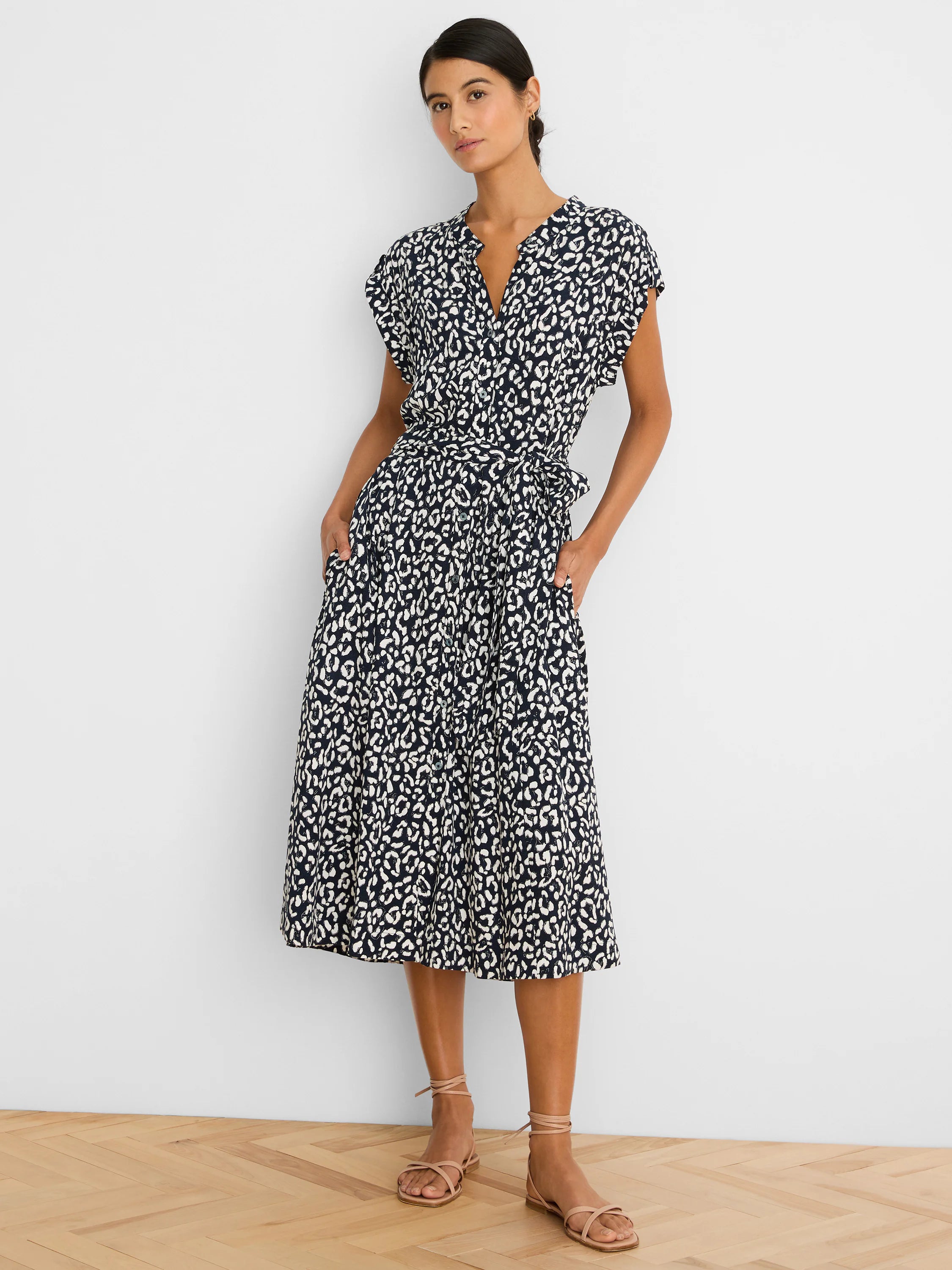 Midi dress with navy and white leopard sketch pattern, V-neck, short sleeves, tie belt, and pockets.