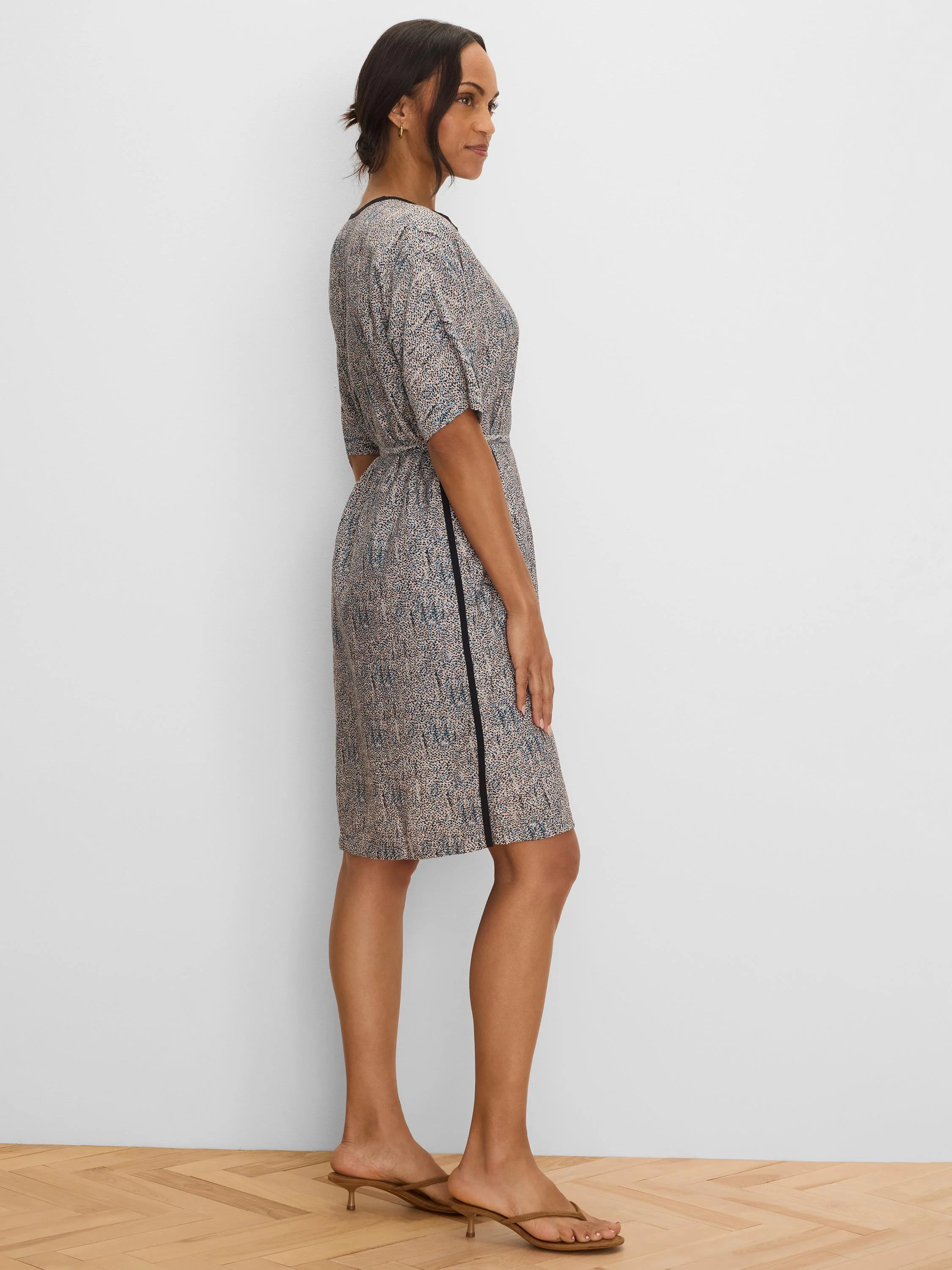 Knee-length dress with beige, blue & black speckle print. Features black trim at neckline and a vertical black side stripe.