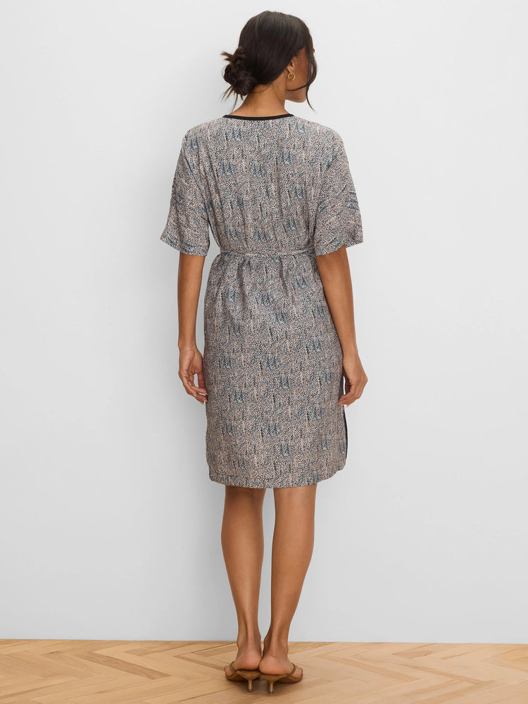 Short-sleeved, knee-length dress with a beige and blue speckled pattern and black neckline trim. Belted waist.