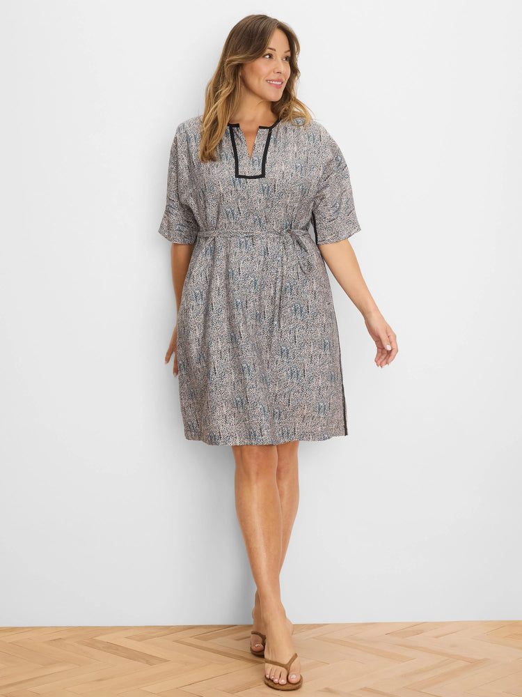 Knee-length dress with beige, blue, and black speckled pattern, short sleeves, V-neck with black trim, and tie waist.