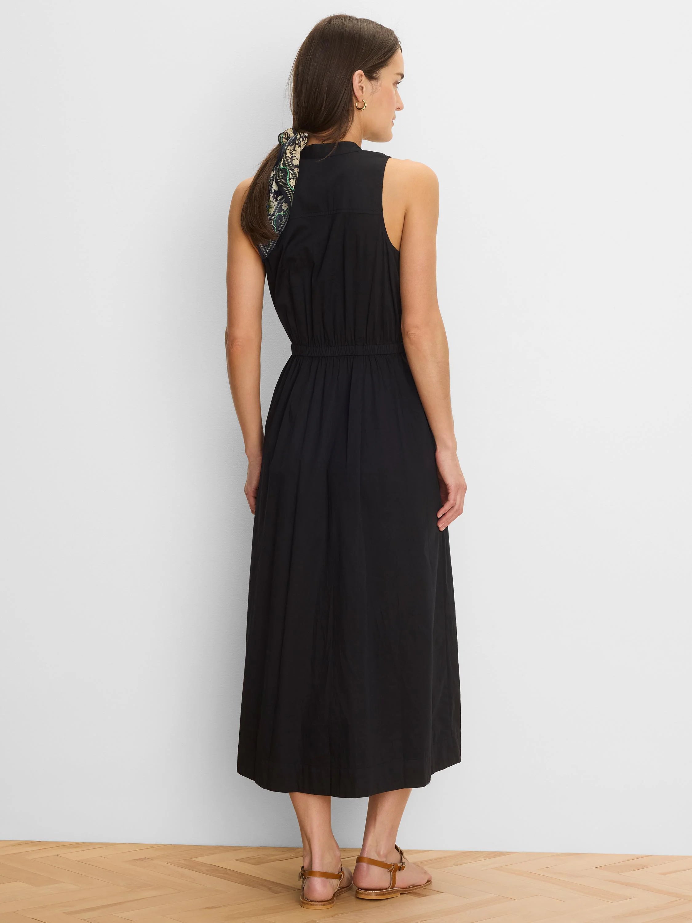 Black sleeveless midi dress with a high neck and elasticated waist, seen from the back.