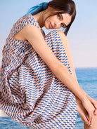 Cap sleeve dress with salmon pink, navy, and beige geometric arc pattern, elastic waist.
