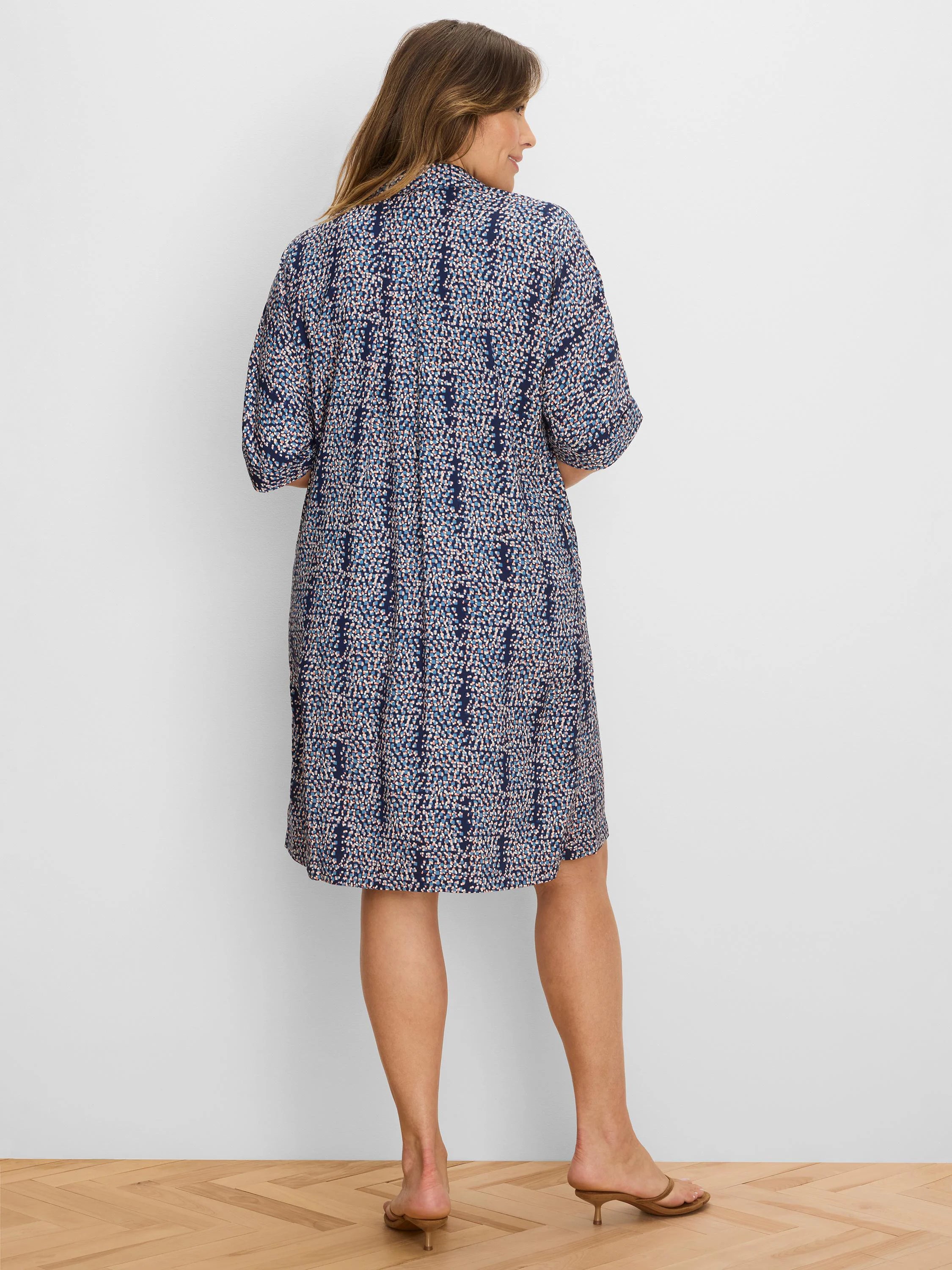 Navy dress with scattered light blue and peach block pattern. Knee-length, short sleeves, relaxed fit.