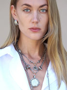 Silver layered necklace with coin & horsebit pendant.  Features a large, irregular silver coin-shaped charm.  Smaller...