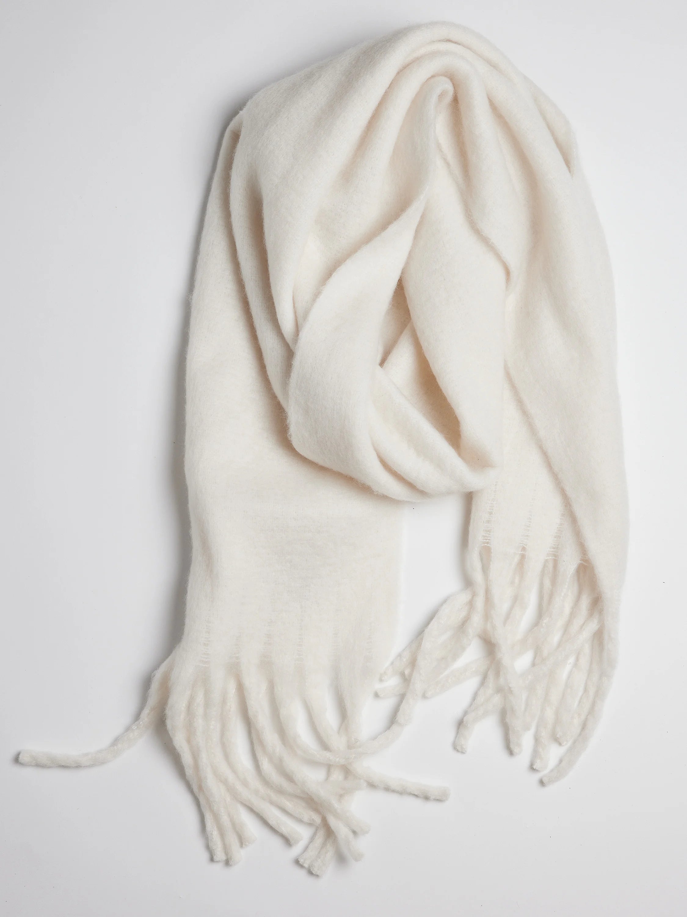 Off-white rectangular scarf with fringe.  Soft, fuzzy texture.