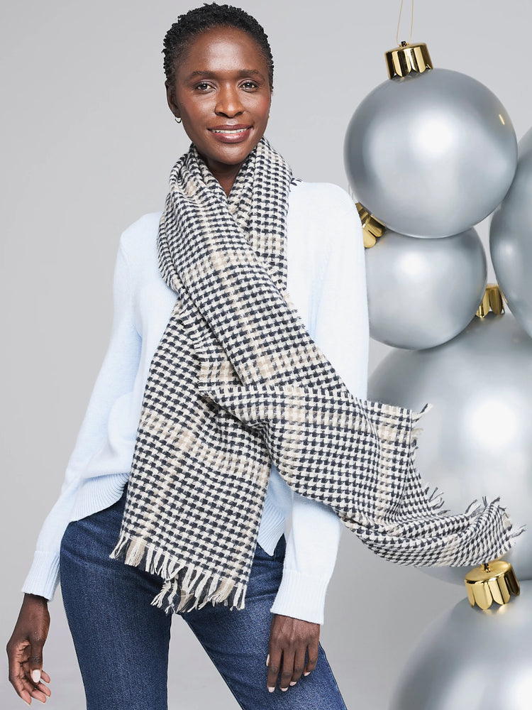 Black, beige, and off-white houndstooth patterned scarf with frayed edges.