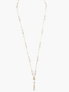 Long gold chain necklace with off-white pearls and a single, larger off-white pearl drop.