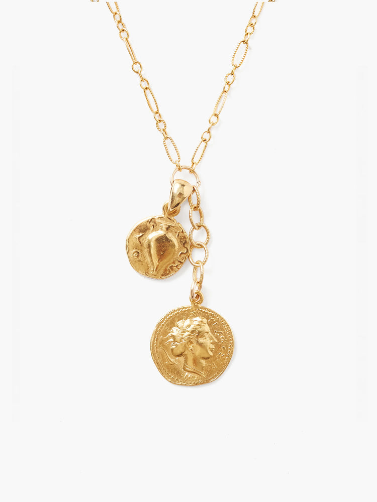 Gold necklace with textured chain. Two gold charms: a smaller round disc with a raised design, and a larger coin with a...
