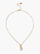 Gold chain necklace with a large off-white pearl pendant.