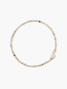 Small, flat, multicolor African opal beads form a necklace. It has a large white baroque pearl and gold hook clasp.