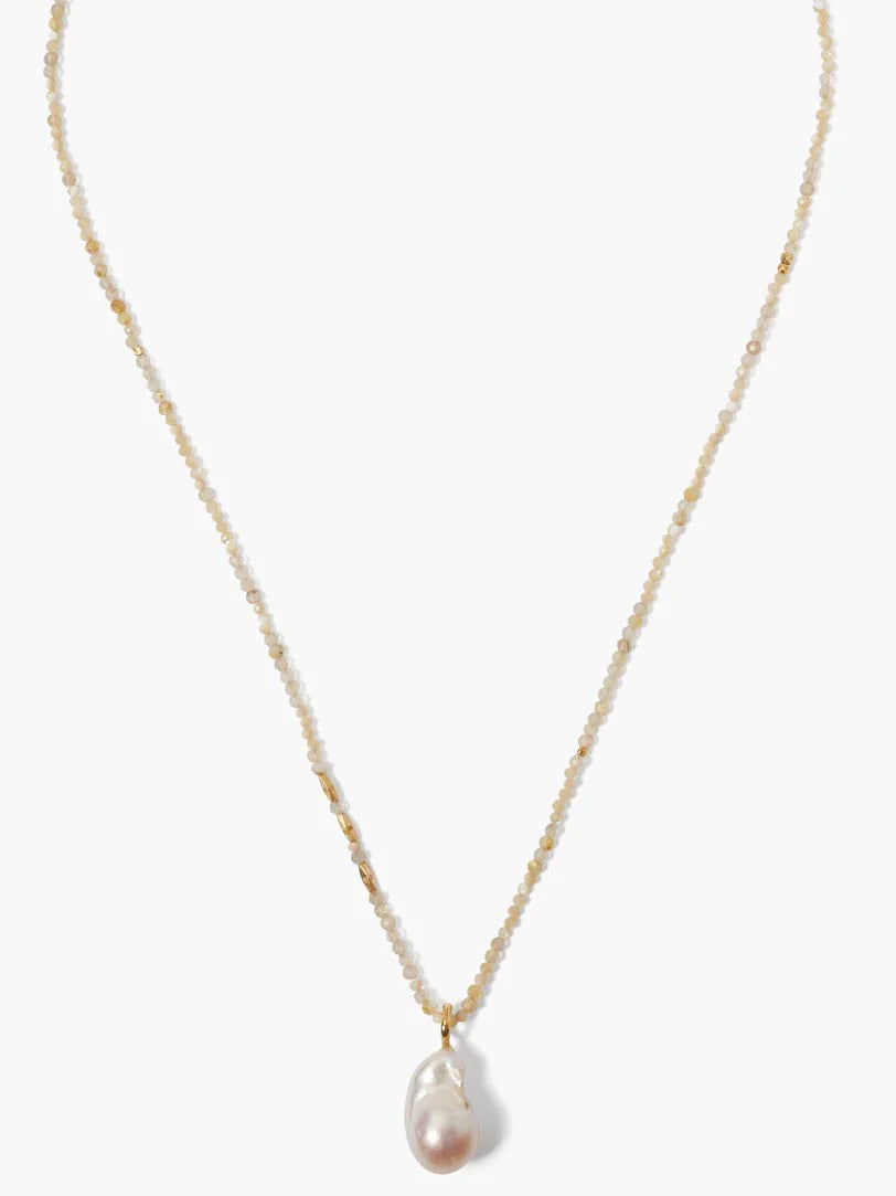 Pale iolite beaded necklace with gold accents and a large, irregular pinkish pearl pendant.