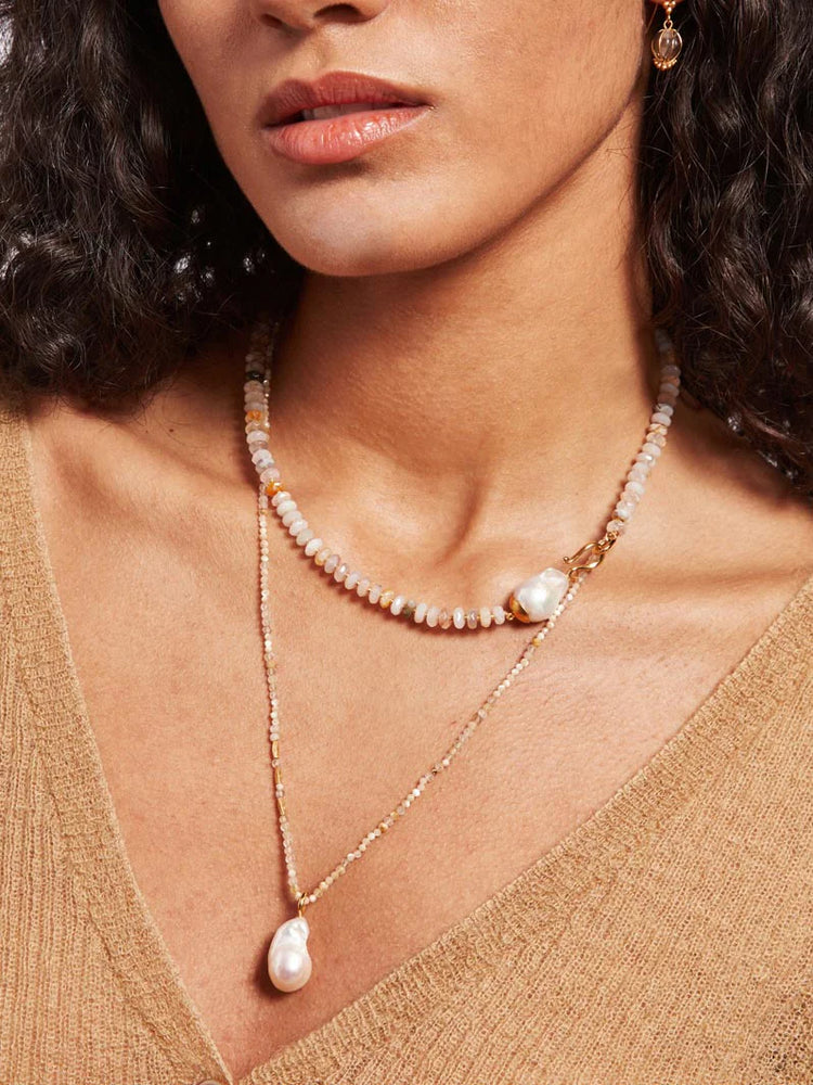 Layered necklace: gold chain with small, light-pink, and tan beads.  Features a large baroque pearl pendant and a smaller...