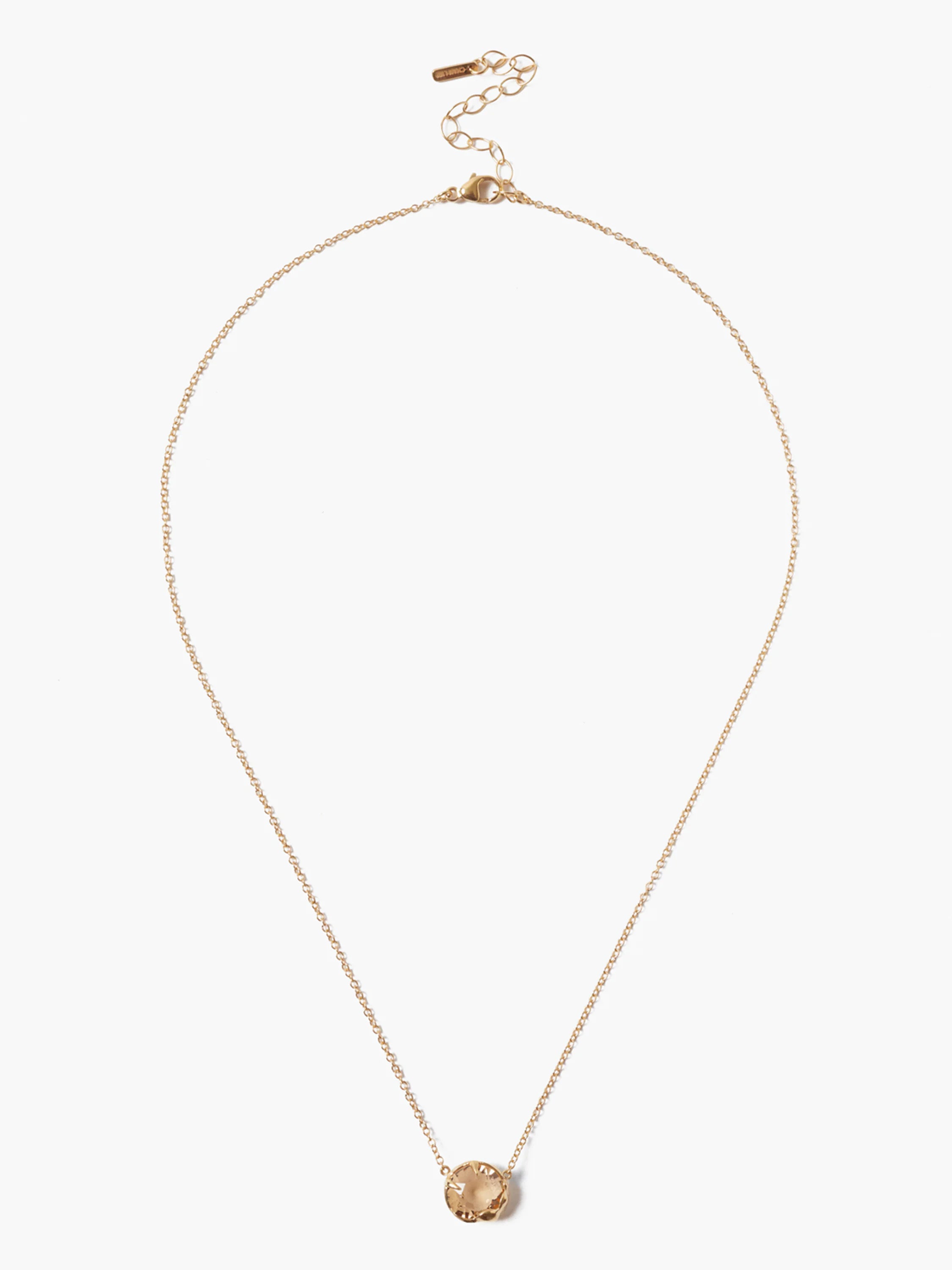 Gold-tone chain necklace with a round, faceted, translucent light brown stone pendant. Features a lobster clasp and extender.