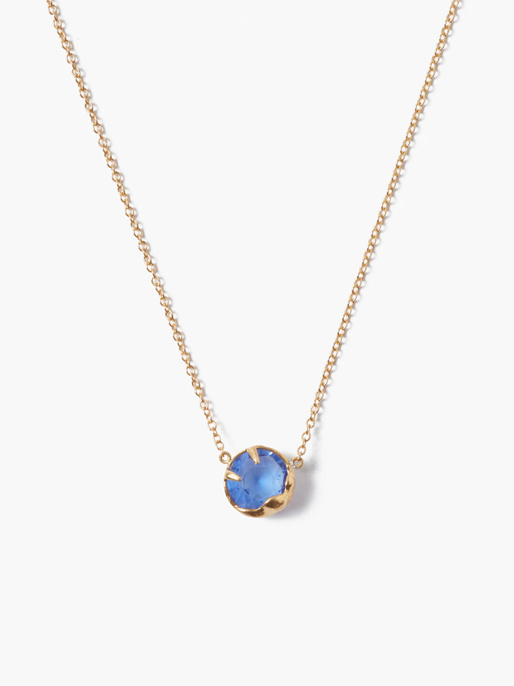 Gold chain necklace with a single, round, blue stone pendant.