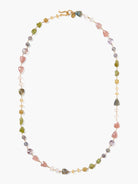 Gold chain necklace with pink, green, and purple stones of varying shapes and sizes.