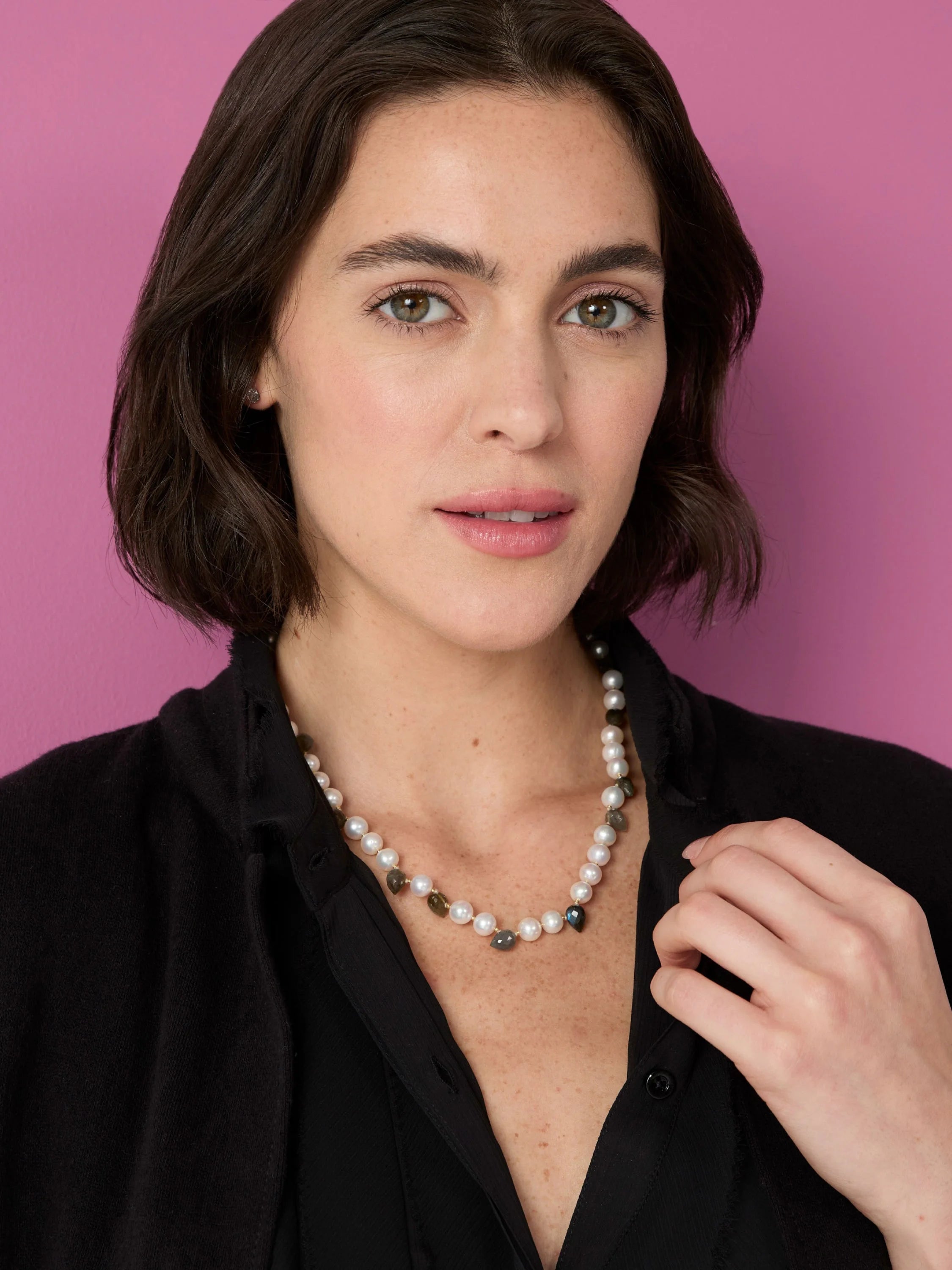 Off-white pearls mixed with irregular, faceted stones in dark green, grey, and iridescent blue.