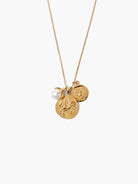 Gold chain necklace with three pendants: a large gold coin with a winged horse, a smaller gold coin with a bird, and a...