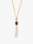 Gold chain necklace with a light blue round stone, dark red rectangular stone, and irregular white pearl drop.