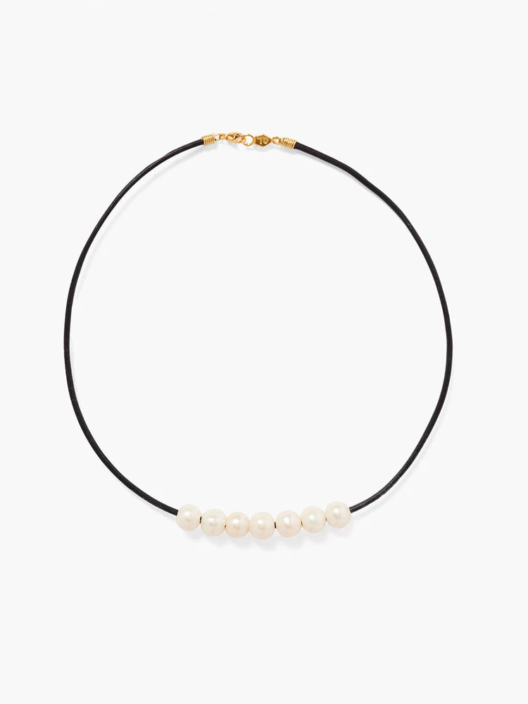 Black leather necklace with seven cream pearls across the front. Features a gold-toned clasp.