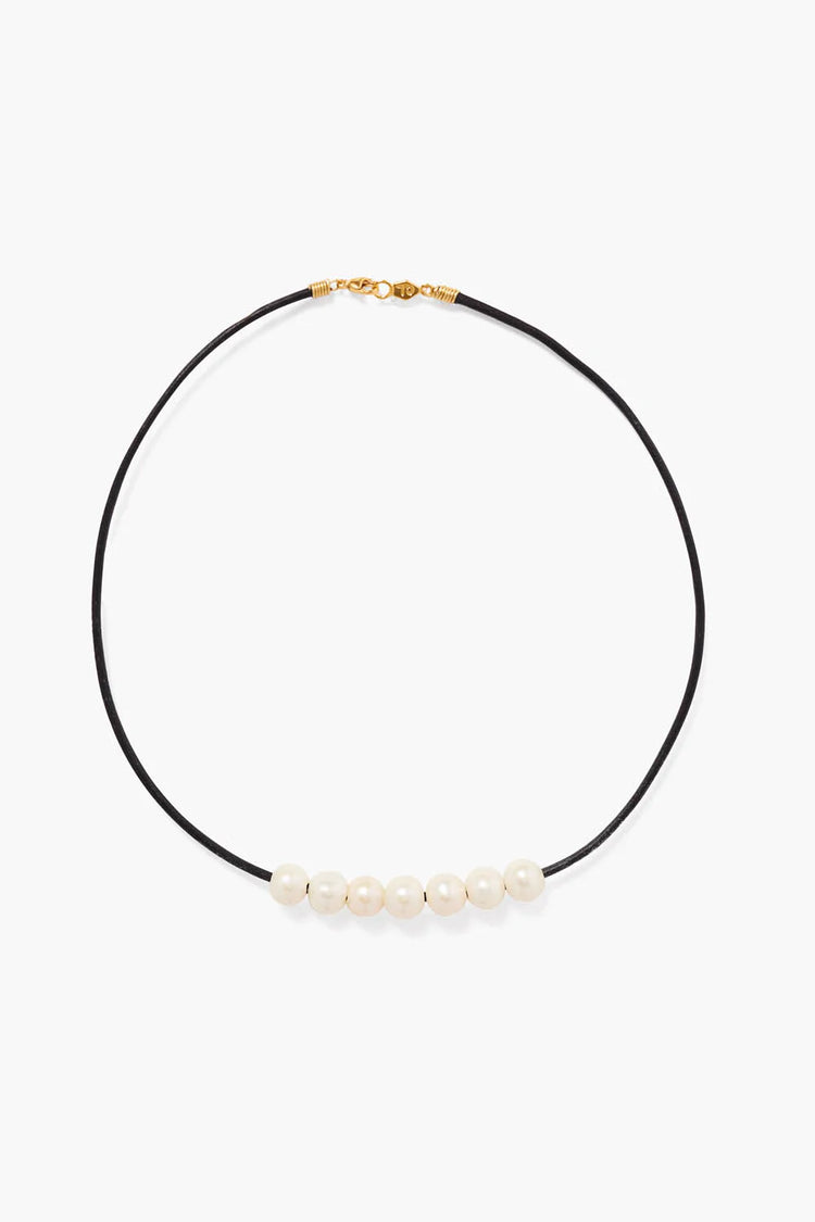 Black leather cord necklace with gold clasp, featuring six off-white pearls.