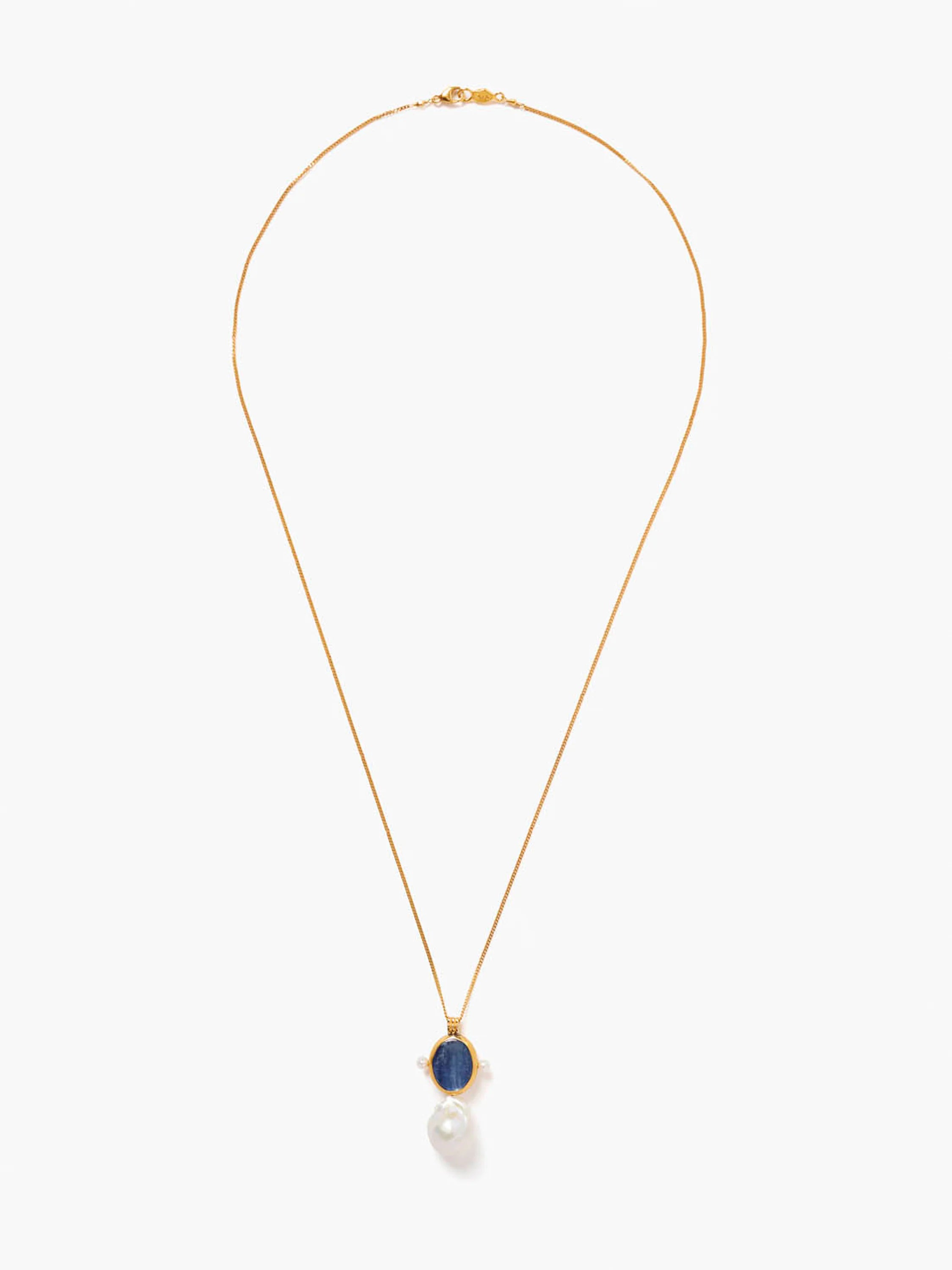 Gold chain necklace with a dark blue oval kyanite stone pendant, accented by two small pearls and a larger baroque pearl.