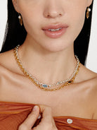 Layered necklace with gold & silver chains, a dark rectangular smokey quartz, & a light blue marquise stone.