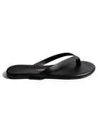 These black leather minimalist thong sandals feature a flat sole and thin, narrow crossover straps.