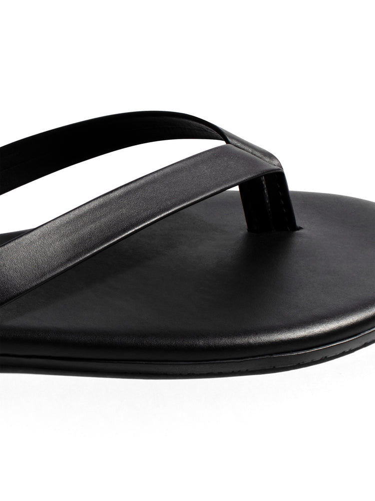 Simple black leather thong sandal with smooth, wide straps and a flat, minimalist sole.