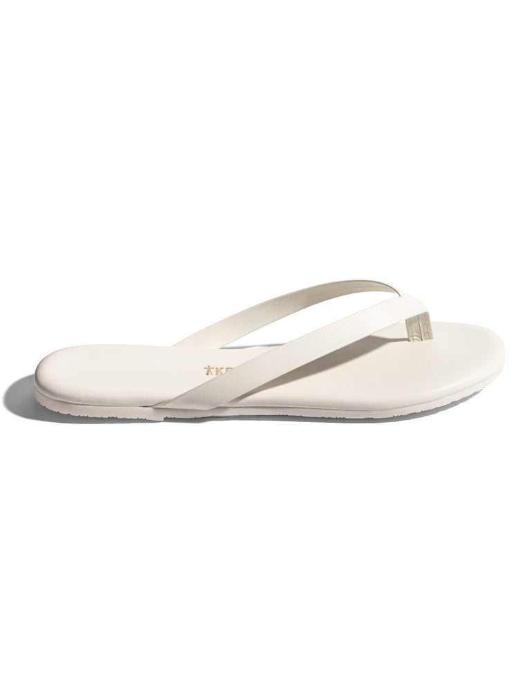 Minimalist off-white leather flip-flops with thin straps and a flat, smooth sole.