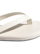 Minimalist off-white leather flip-flop featuring a flat sole and streamlined straps for a modern, casual look.