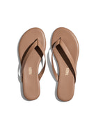 The flat, minimalist nude leather flip-flops feature thin straps and a simple, rounded sole design.